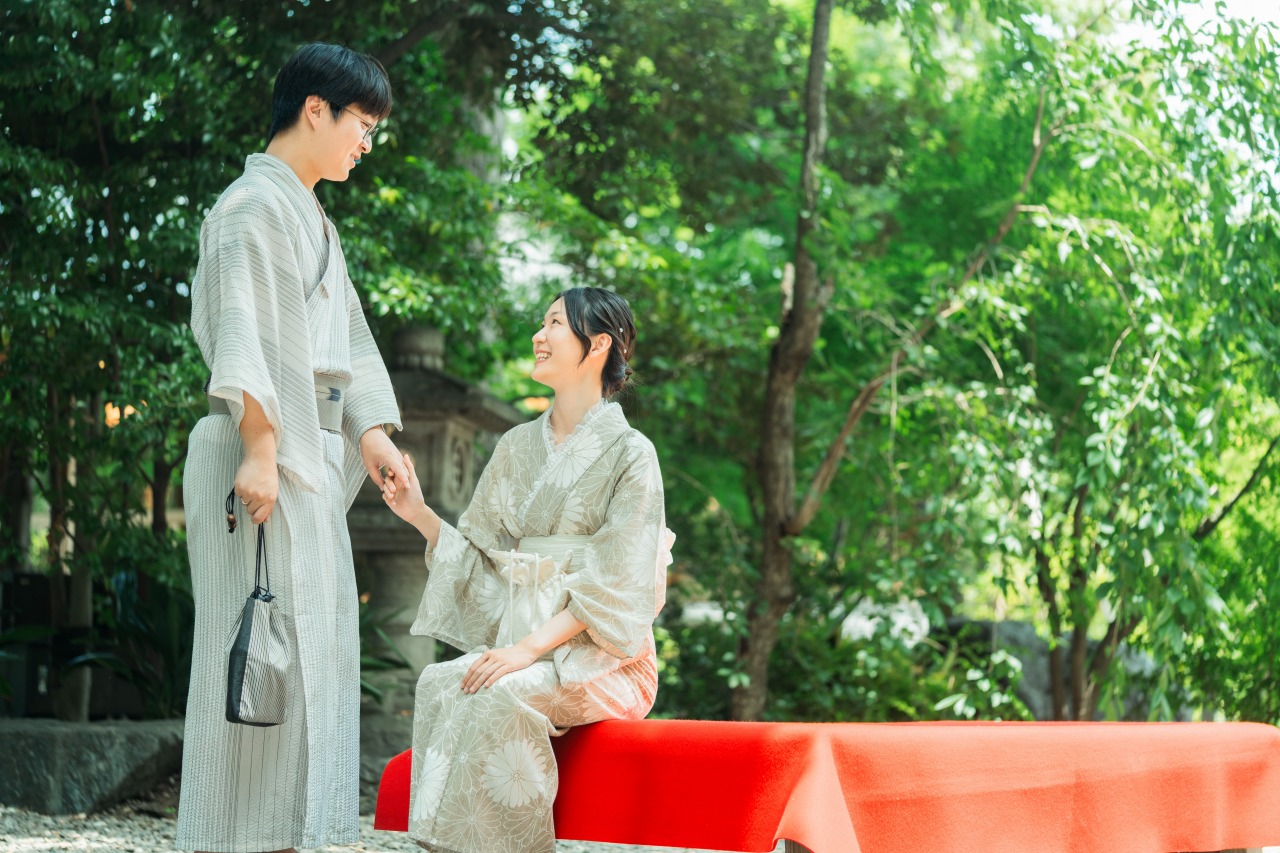 Kawagoe photoshoot traveler couple by a red bench in a lush green garden