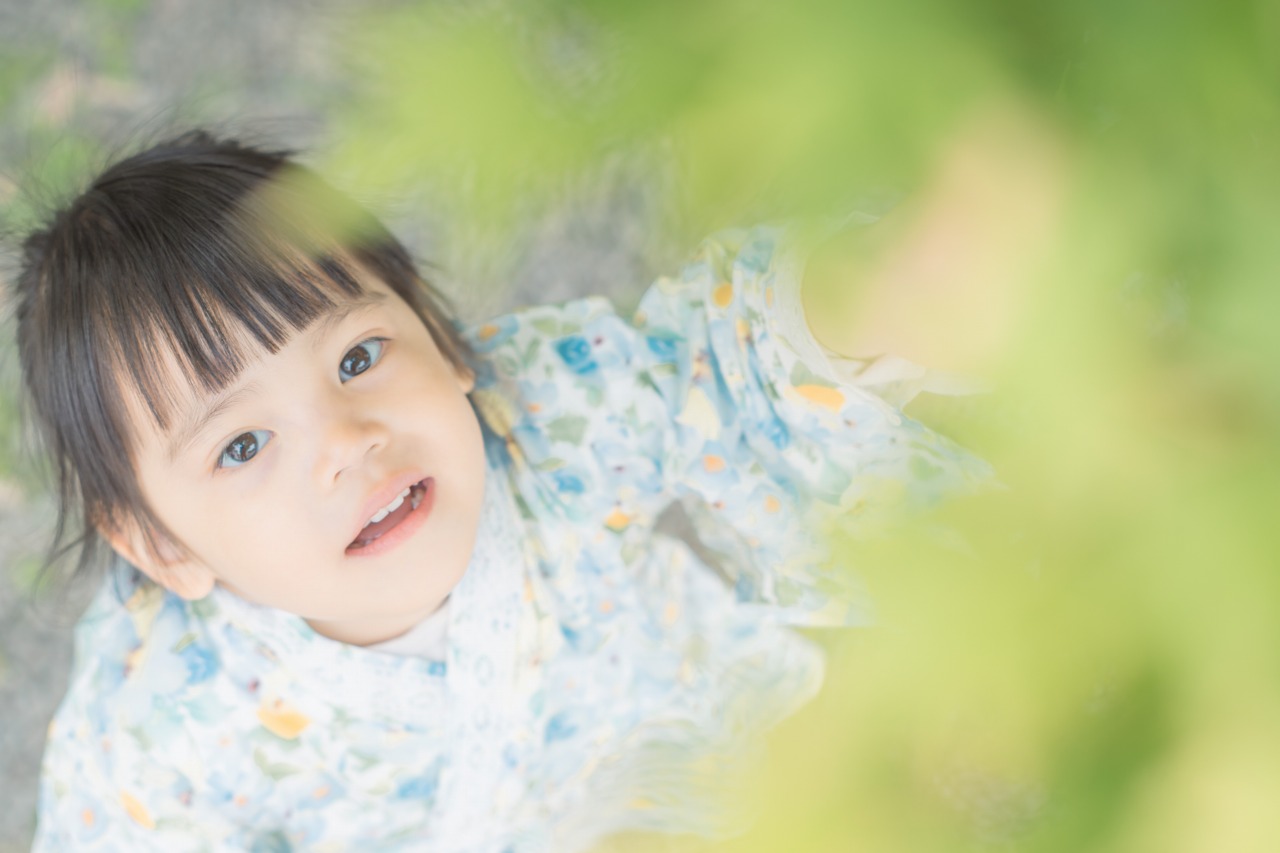 Osaka Castle Park child portrait – lying in grass with soft foreground