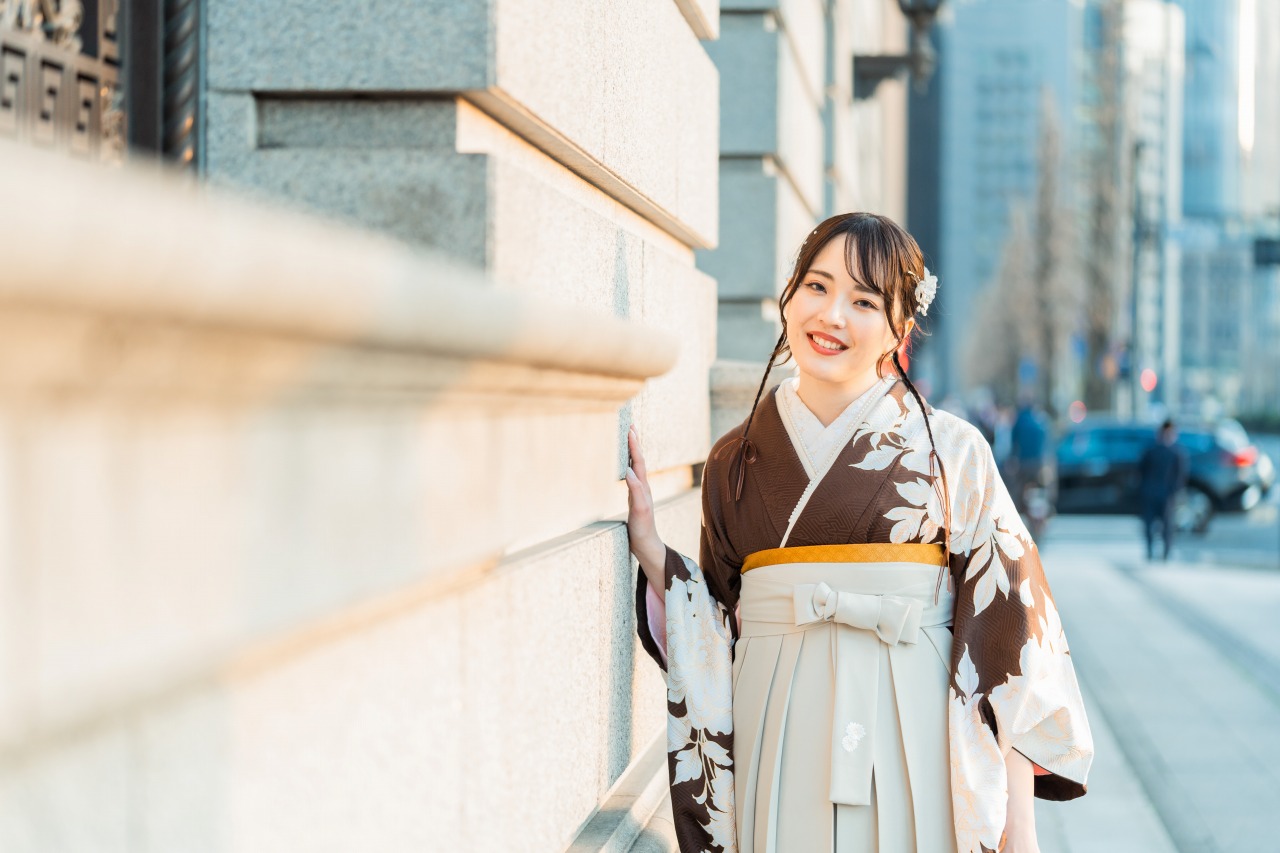 Marunouchi street portrait – kimono close-up leaning on wall, soft evening light