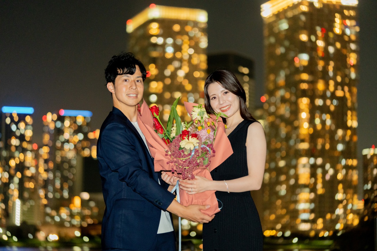 Tokyo night photoshoot by waterfront skyline – proposal bouquet, city lights bokeh