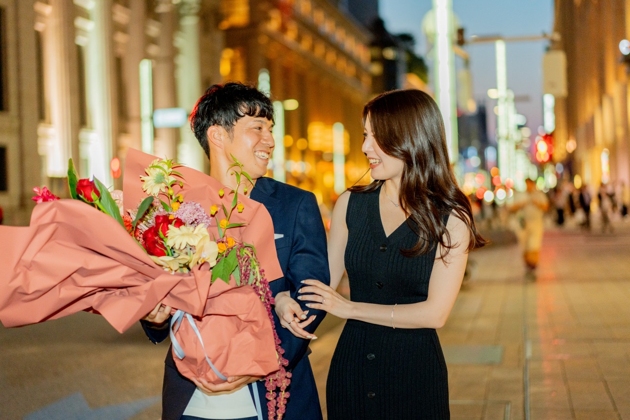 Tokyo evening street portrait - couple with bouquet, city glow