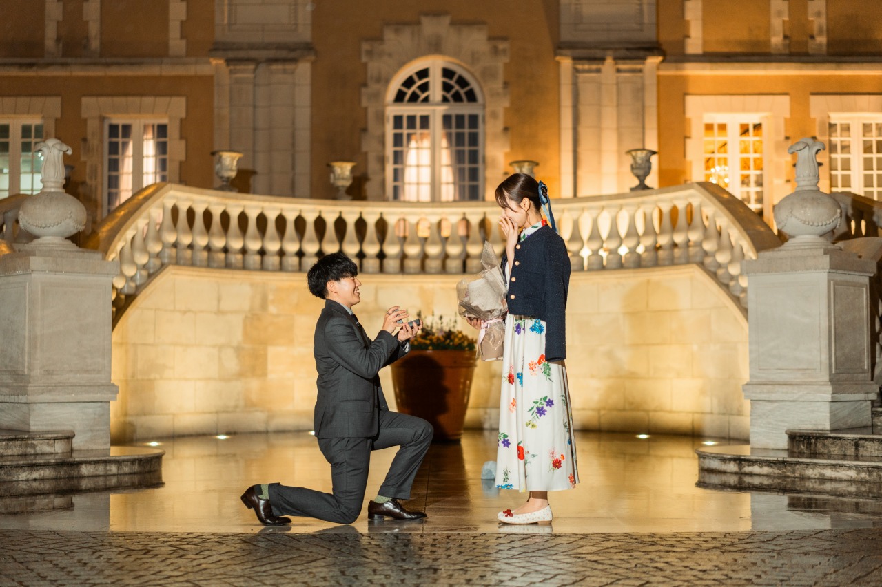 Tokyo proposal photoshoot - kneeling moment on plaza steps, night lights