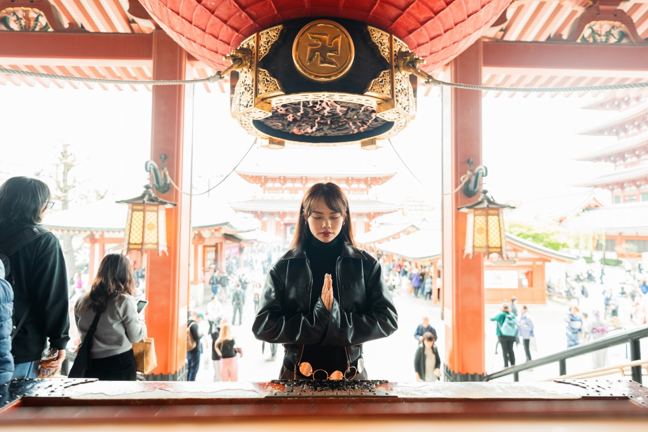 Temple praying scene - woman at offering box, hands together