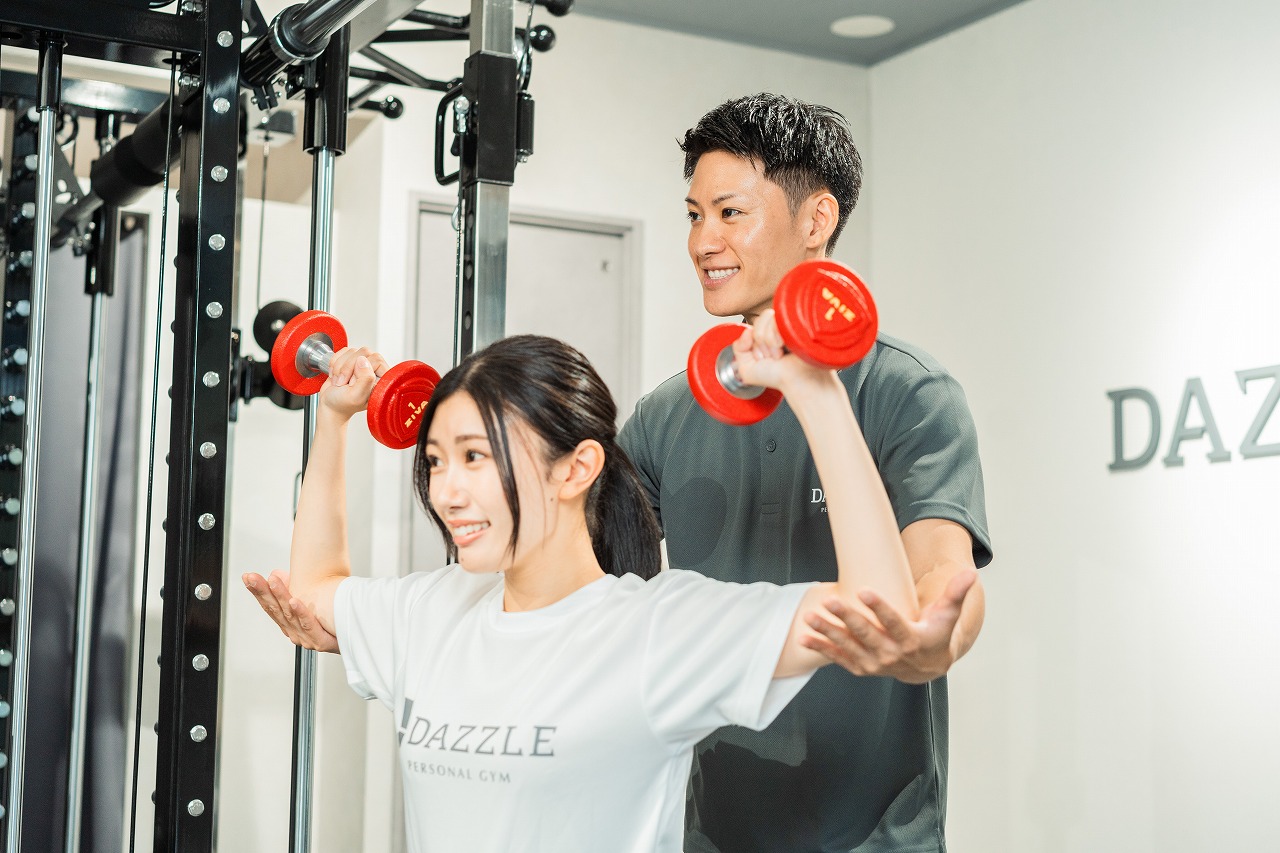 トレーナーに指導を受ける女性写真