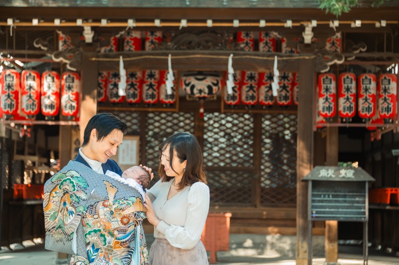 大阪天満宮 お宮参り 提灯並ぶ拝殿前で夫婦と赤ちゃん