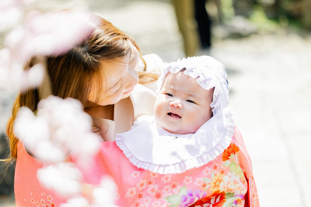 中山寺 お宮参り ママと赤ちゃん 本殿近くの木陰 桜の前ボケで春の柔らかい光