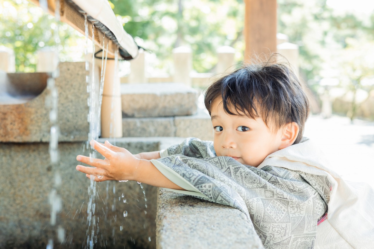 手水舎で手を清める七五三の男の子