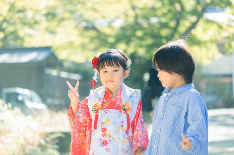 日吉大社 七五三 きょうだい写真 境内で赤い着物の女の子と男の子が並ぶ