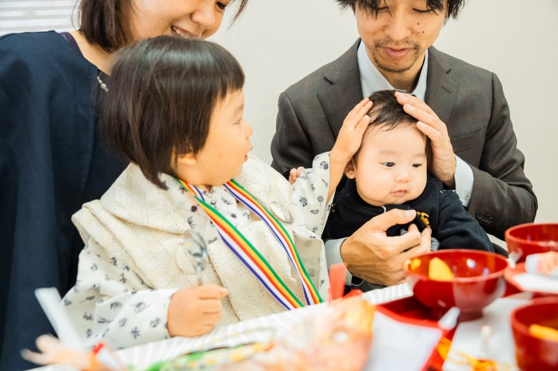 神戸 お食い初め 家族で赤ちゃんを囲む微笑ましい儀式シーン