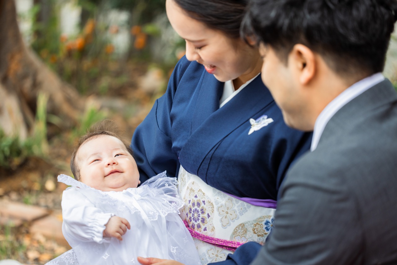 尼崎・水堂須佐男神社でのお宮参り写真 親子が赤ちゃんを見つめる
