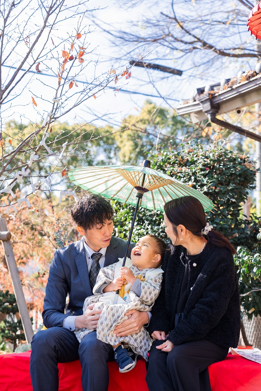 水堂須佐男神社 七五三 家族写真 和傘を差してベンチに座る記念ショット