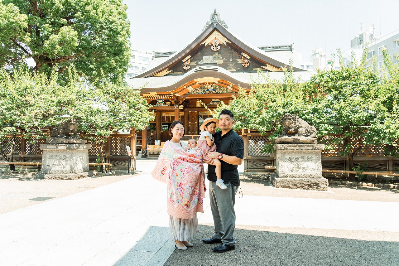 湯島天神 お宮参り 夫婦と赤ちゃんの家族写真 拝殿前で並ぶ記念ショット