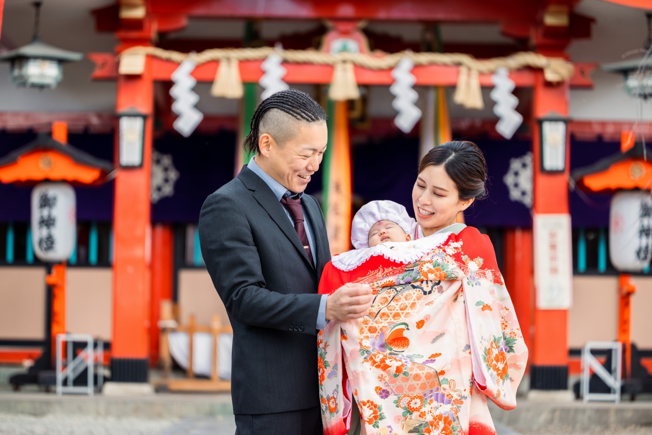 生島神社 お宮参り 祝着の赤ちゃんを抱くツーショット 拝殿前で記念撮影