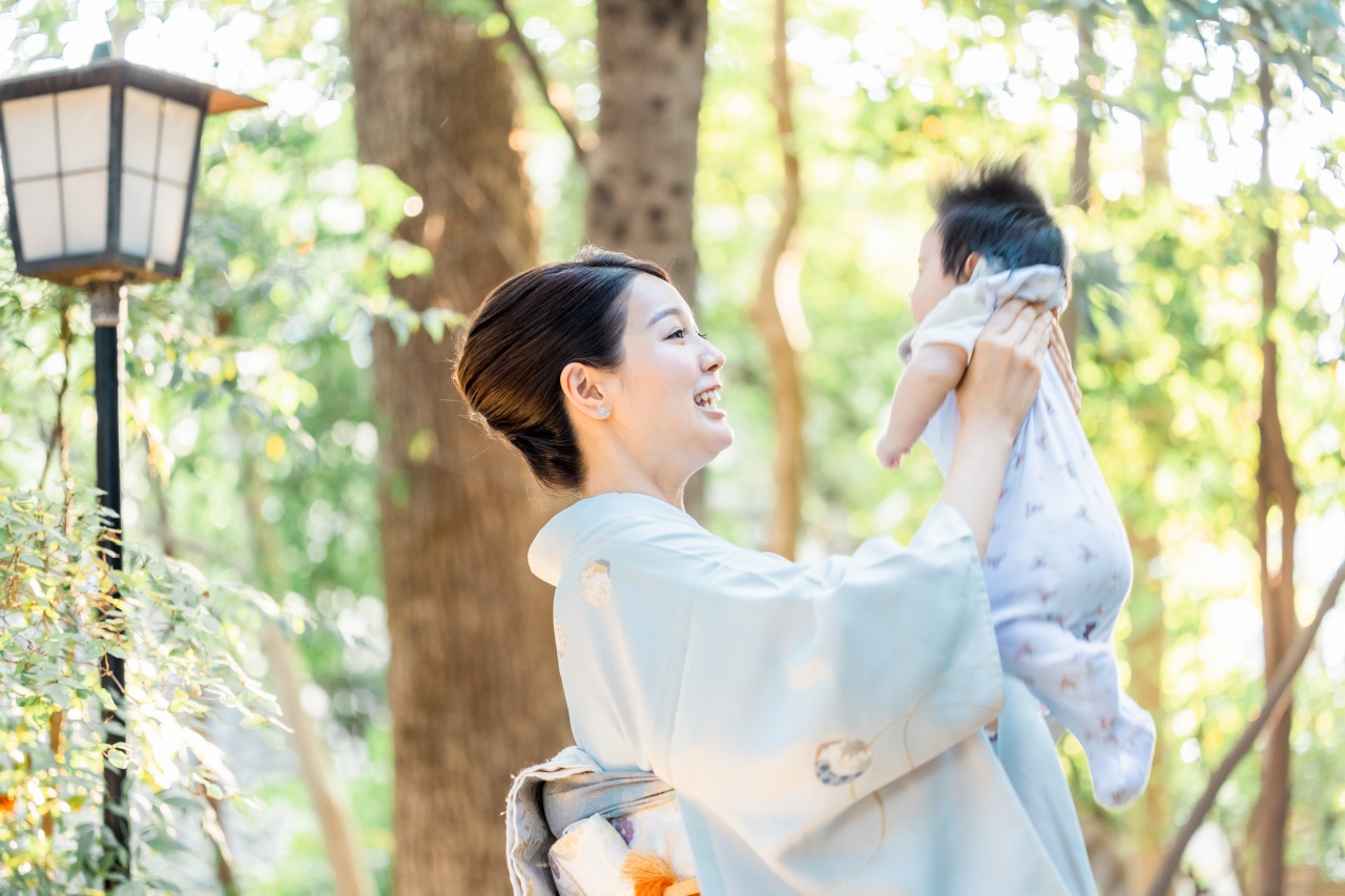 芦屋神社 緑の中で お母さんが赤ちゃんを高い高い