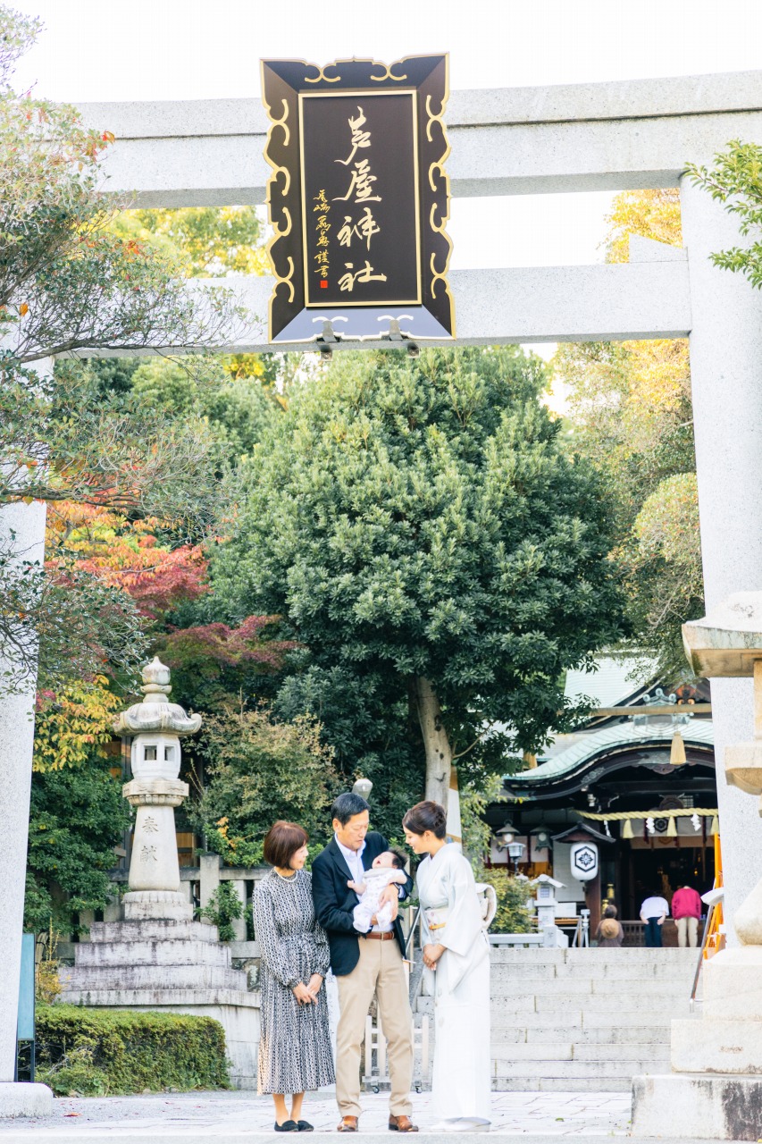芦屋神社 お宮参り 大鳥居の下で家族ショット 石碑と参道が写るロングカット